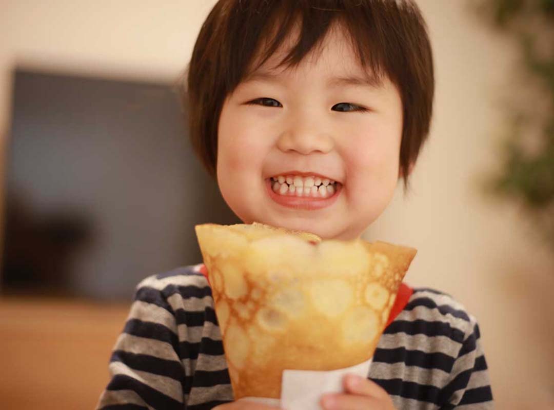 家に届いたクレープを持っている子供の画像
