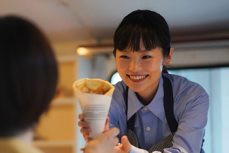 買い上げ出店プランでキッチンカーからお客様へクレープを提供している画像