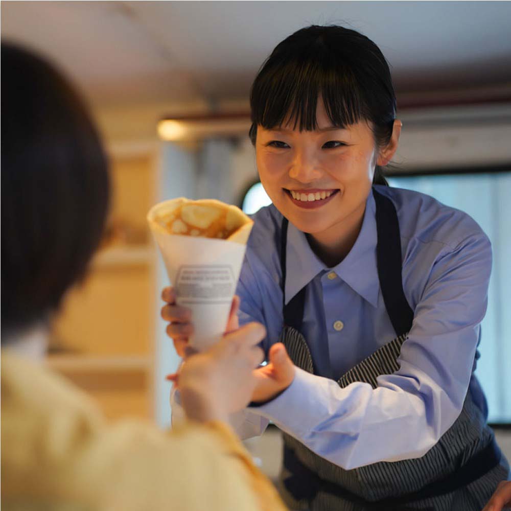 買い上げ出店プランでキッチンカーからお客様へクレープを提供している画像